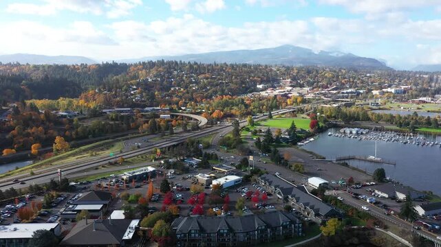 4K aerial drone footage of  Hood River town in Oregon in fall colors, gas stations, famous hotel,  Columbia River marina with boats, mountains in the background