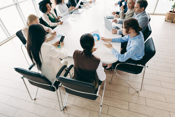 Collaborative business meeting of diverse coworkers discussing project strategy in a modern office setting