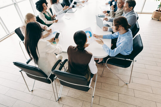 Collaborative business meeting of diverse coworkers discussing project strategy in a modern office setting