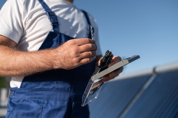 Man checking condition of solar panels during sunny day