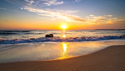 Golden sun dips below horizon, painting the beach and sea in warm light. Waves gently lap the shore