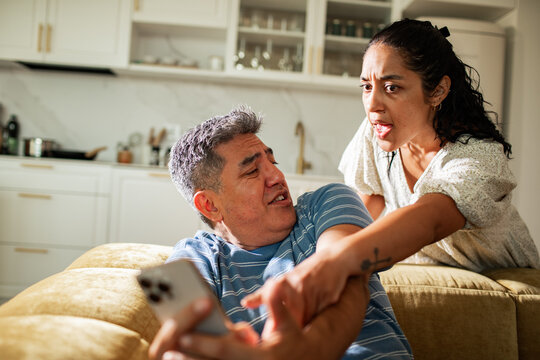 Middle aged couple arguing and yelling at each other over a phone