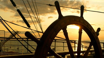 sunset through an antique ship's wheel