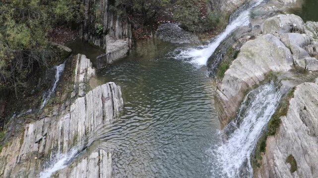 R&iacute;o fluyendo a trav&eacute;s de un ca&ntilde;&oacute;n rocoso o garganta. El agua desciende a trav&eacute;s de una serie de peque&ntilde;as cascadas y r&aacute;pidos,