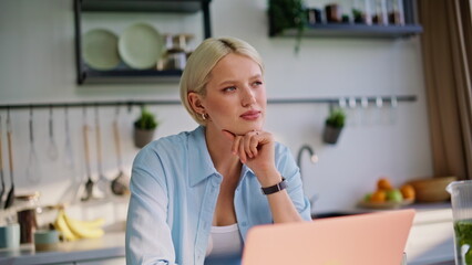 Dreamy lady thinking ideas working laptop at kitchen closeup. Woman drinking tea