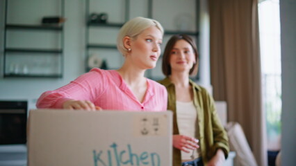 Women homeowners unpacking boxes organizing home space after moving closeup