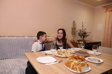 Sister and brother having fun at the festive Christmas or New Year's table.