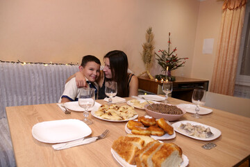 Sister and brother having fun at the festive Christmas or New Year's table.