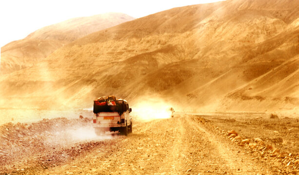 A car running on a dusty off road in ladakh, India