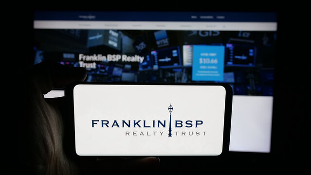 Stuttgart, Germany - 10-30-2025: Person holding cellphone with logo of US company Franklin BSP Realty Trust Inc. on screen in front of webpage. Focus on phone display.