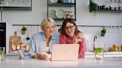 Best friends talking virtual call looking computer screen at kitchen closeup