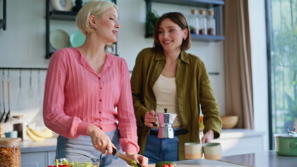 Closeup hands chopping vegetables in kitchen countertop. Lgbt couple cooking