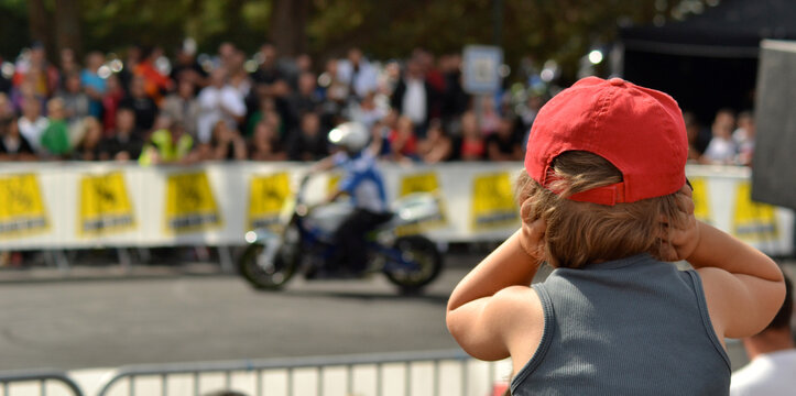 Gar&ccedil;on de dos se bouchant les oreilles lors d'un show motos