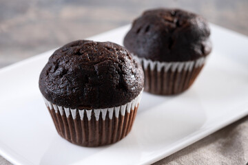 Homemade chocolate muffins on wooden table