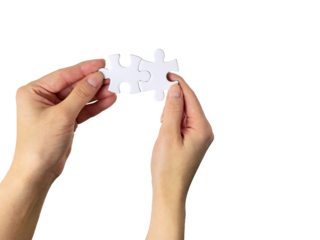 Hands connecting two white jigsaw puzzle pieces together