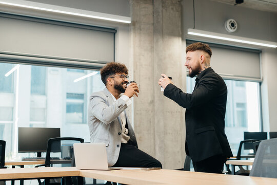 Diverse business professionals enjoying coffee break in modern office