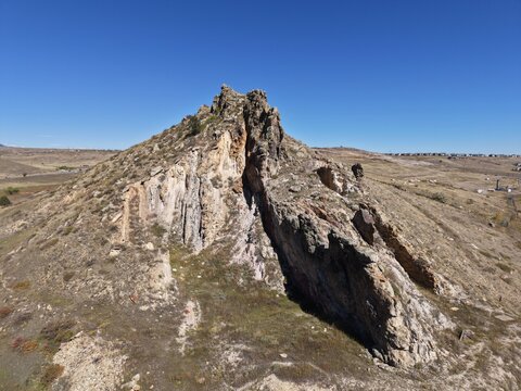 Drone view of rugged Arvada Colorado mountain peak with deep rocky crevice and vast landscape