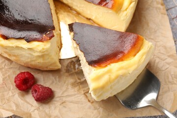 Pieces of tasty Basque cheesecake with raspberries on grey table, above view