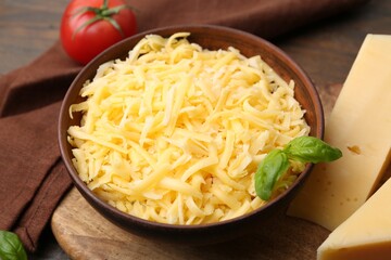 Grated and pieces of cheese on wooden table, closeup