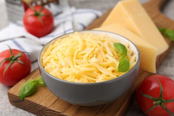 Grated and pieces of cheese, tomatoes, basil on grey table, closeup
