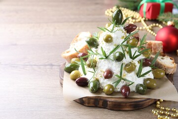 Delicious Christmas tree cheese ball with olives, rosemary and decor on wooden table, closeup with space for text. New Year's appetizer
