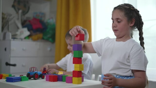 Children play home engaging learning development activities with family. Building colorful blocks stacking rings foster creativity fine motor skills growth. Family supports children learning journey.