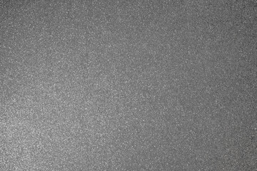 Silver glitter texture with fine granular relief, macro focus reveals shimmering sparkles scattered evenly across abstract metallic surface
