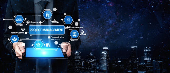 A businessman holds a tablet displaying project management icons, set against a stunning city...