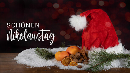 Schönen Nikolaustag, Nikolaus Grußkarte mit deutschem Text - Nikolausmütze im Schnee, isoliert...