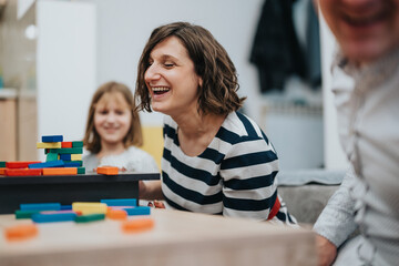 Fototapeta premium A family spending joyful moments together at home, playing and sharing laughter with colorful blocks, symbolizing love, bonding, and togetherness.