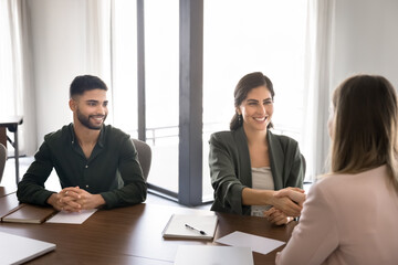 Happy Mexican businesswoman shaking hands with female client