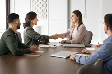 Two businesswomen shaking hands as gesture of successful agreement