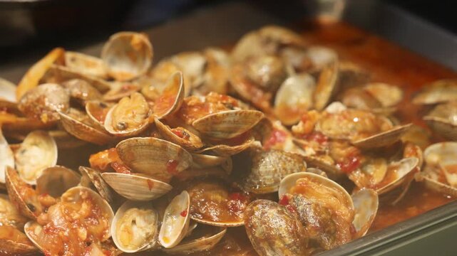 Fresh clams cooked in vibrant marinara sauce, creating a savory and rich seafood stew. Step-by-step preparation highlighting fresh ingredients, cooking process, and delicious international cuisine