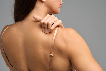 Woman touching neck and shoulder showing muscle strain and upper back pain