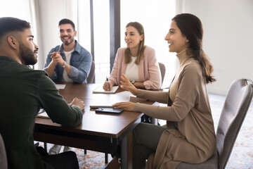 Group of professionals gathered around meeting table in modern office