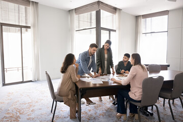 Fototapeta premium Diverse team reviewing printed charts during briefing or brainstorming session