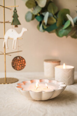 Handmade scented candles in ceramic vessels in a Christmas display