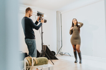 Photographer capturing a model posing in a well equipped studio setting with lighting equipment. The model displays confidence, showcasing a perfect collaboration for fashion, portrait or commercials.
