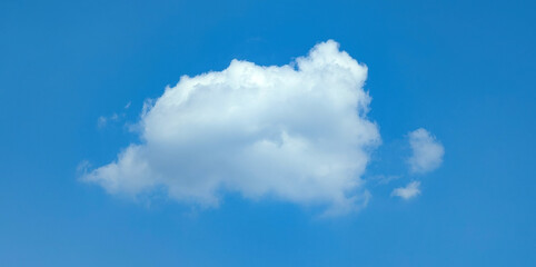 One cumulus Cloud In majestic flight on blue sky. Isolated steam curl with soft circle shapes and warm textured. Glare Highlights and shadows from the sun.