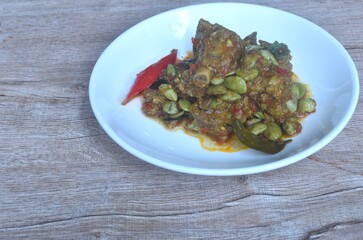 spicy fried pork bone and flat bean with curry on plate