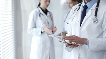 Healthcare professional using a digital tablet for patient data management, doctors collaborating on medical records, modern clinic team focusing on health technology - Powered by Adobe