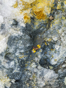 Aerial view of the volcanic landscape reveals textures of mineral deposits and sulfurous vents, creating a surreal canvas of nature's artistry, Mount Ijen, East Java, Indonesia.