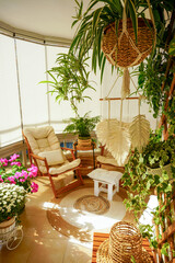 Cozy balcony interior with indoor plants, boho and Scandinavian style decor, natural light and rattan furniture creating a bright, relaxing home atmosphere
