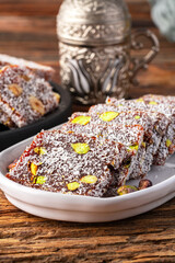 Turkish delight cezerye with pistachio or hazelnut on wooden background. Cezerye, a traditional dessert from the Mersin region