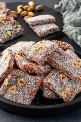 Turkish delight cezerye with pistachio or hazelnut on black background. Cezerye, a traditional dessert from the Mersin region
