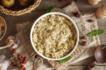 Fermented cabbage or sauerkraut in a white bowl on a table
