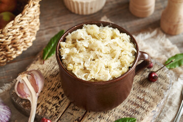 Fermented cabbage or sauerkraut in a brown pot with garlic and spices