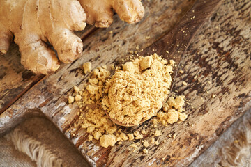 Ginger powder and fresh root on a table