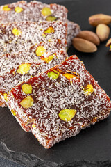 Turkish delight cezerye with pistachio or hazelnut on black background. Cezerye, a traditional dessert from the Mersin region