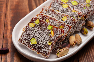 Turkish delight cezerye with pistachio or hazelnut on wooden background. Cezerye, a traditional dessert from the Mersin region